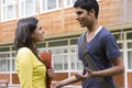 Male and female college students talking on campus