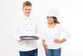 Male and female cooks in uniform hold empty tray isolated on white background