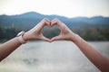 male and female couple showing their hands up to form heart symbol to show friendship love and kindness because heart is symbol of