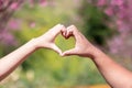 male and female couple showing their hands up to form heart symbol to show friendship love and kindness because heart is symbol of