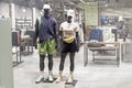 male and female dark-skinned mannequin in sportswear and caps in a shop window. casual fashion