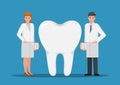 Male and female dentist standing with big tooth