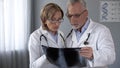 Male and female doctors looking at lungs x-ray, discussing pneumonia diagnosis Royalty Free Stock Photo