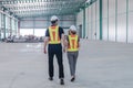 Male and female engineers are walking in warehouse