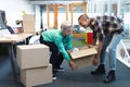 Male and female executives carrying cardboard boxes in office Royalty Free Stock Photo