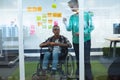 Male and female executives discussing over sticky notes in office Royalty Free Stock Photo