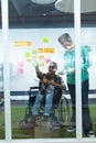 Male and female executives discussing over sticky notes in office Royalty Free Stock Photo