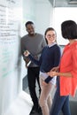 Male and female executives discussing on whiteboard Royalty Free Stock Photo