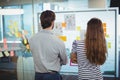 Male and female executives looking at whiteboard in office Royalty Free Stock Photo