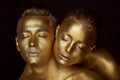 Male and female face around. The woman`s head lies on the shoulder of a man.All painted in gold paint, the feeling of a