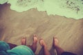 Male and female feet couple are standing on the sandy beach Royalty Free Stock Photo