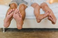 male and female feet people sitting on the bed