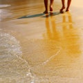 Male and female feet walk on the sandy beach Royalty Free Stock Photo