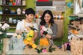 Male and female florists with beautiful bouquets in flower shop.