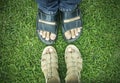 Male and female foots on green grass.
