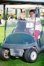 Male and female golf partners using golf cart