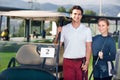 Male and female golf players driving golf cart at golf course Royalty Free Stock Photo