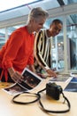 Male and female graphic designers discussing over photographs at desk Royalty Free Stock Photo