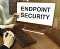 Male and female hand, computer with text Endpoint Security with office background