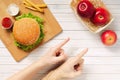 Male and female hand, fingers indicate apples, the choice between healthy and junk food. The choice in favor of vegetarianism, a Royalty Free Stock Photo