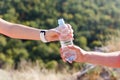 Male and female hand holding plastic bottle of water outdoors Royalty Free Stock Photo