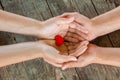 Male and female hands holding red heart on wooden background Royalty Free Stock Photo