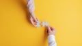 Male and female hands joining two matching puzzle pieces together