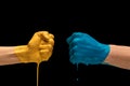 Male and female hands painted blue and yellow gesturing on dark studio background Royalty Free Stock Photo