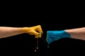 Male and female hands painted blue and yellow gesturing on dark studio background Royalty Free Stock Photo
