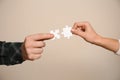 Male and female hands with pieces of puzzle on light background Royalty Free Stock Photo