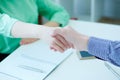 Male and female handshake in office. SPartners made deal, sealed with handclasp.