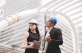 Male and female industrial engineer holding a tablet and blueprints working and discussing on building site,Start up new project Royalty Free Stock Photo