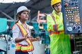 Male and Female Industrial Engineers in Hard Hats Discuss talking. Female industrial engineer standing in a heavy industrial