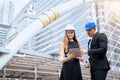 Male and female industrial engineers holding a tablet and blueprints working and discussing on building site Royalty Free Stock Photo