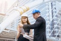 Male and female industrial engineers holding a tablet and blueprints working and discussing on building site Royalty Free Stock Photo