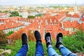 Male and female legs in the background of roofs of Prague city Czech republic on a sunny summer day. Typical Prague Royalty Free Stock Photo