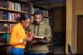 Male and female looking for something in a book in a library Royalty Free Stock Photo