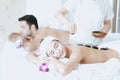 Male and Female massage therapist giving a massage at a spa. Woman having hot stones on her back in spa salon Royalty Free Stock Photo
