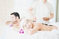 Male and Female massage therapist giving a massage at a spa. Woman having hot stones on her back in spa salon Royalty Free Stock Photo