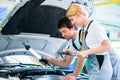 Mechanic team working in car workshop Royalty Free Stock Photo