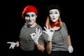 Male and female mime on black background. Cheerful man and woman Royalty Free Stock Photo