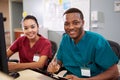 Male And Female Nurse Working At Nurses Station