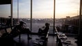 Male and female passengers sitting departure lounge, waiting for plane, travel