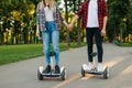 Male and female person riding on gyroboard in park