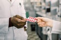 Male And Female Pharmacists or doctors In Pharmacy. Welcome in drugstore. Cropped image of hands of pharmacists or Royalty Free Stock Photo