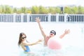 Male and female playing in the pool with a beach ball. Young couple embracing in the pool Royalty Free Stock Photo