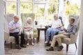 Male And Female Residents Sitting In Chairs And Talking In Lounge Of Retirement Home Royalty Free Stock Photo