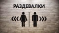 Male and Female Restroom Symbols on a Wooden Wall With Directional Arrows. Gender-specific bathroom signs on wood Royalty Free Stock Photo