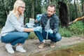 male and female scientists putting sample of water in test flask