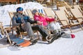Male and female skiers enjoy in sun loungers Royalty Free Stock Photo